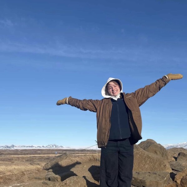 Student standing in front of rocks and mountains in northern Canada