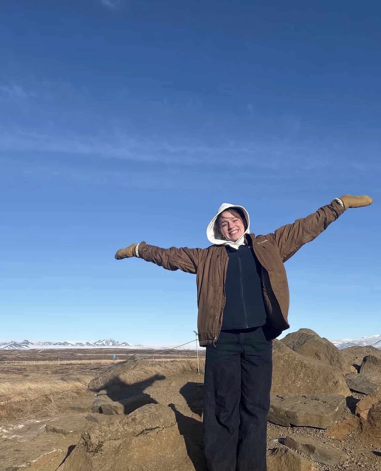 Student standing in front of rocks and mountains in northern Canada