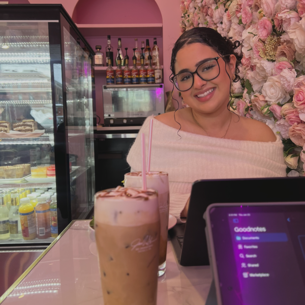 Student in restaurant posing beside flower wall