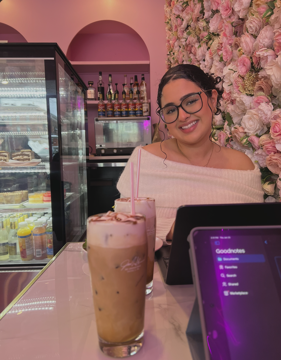 Student in restaurant posing beside flower wall