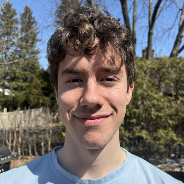 Student with short brown hair posing outside