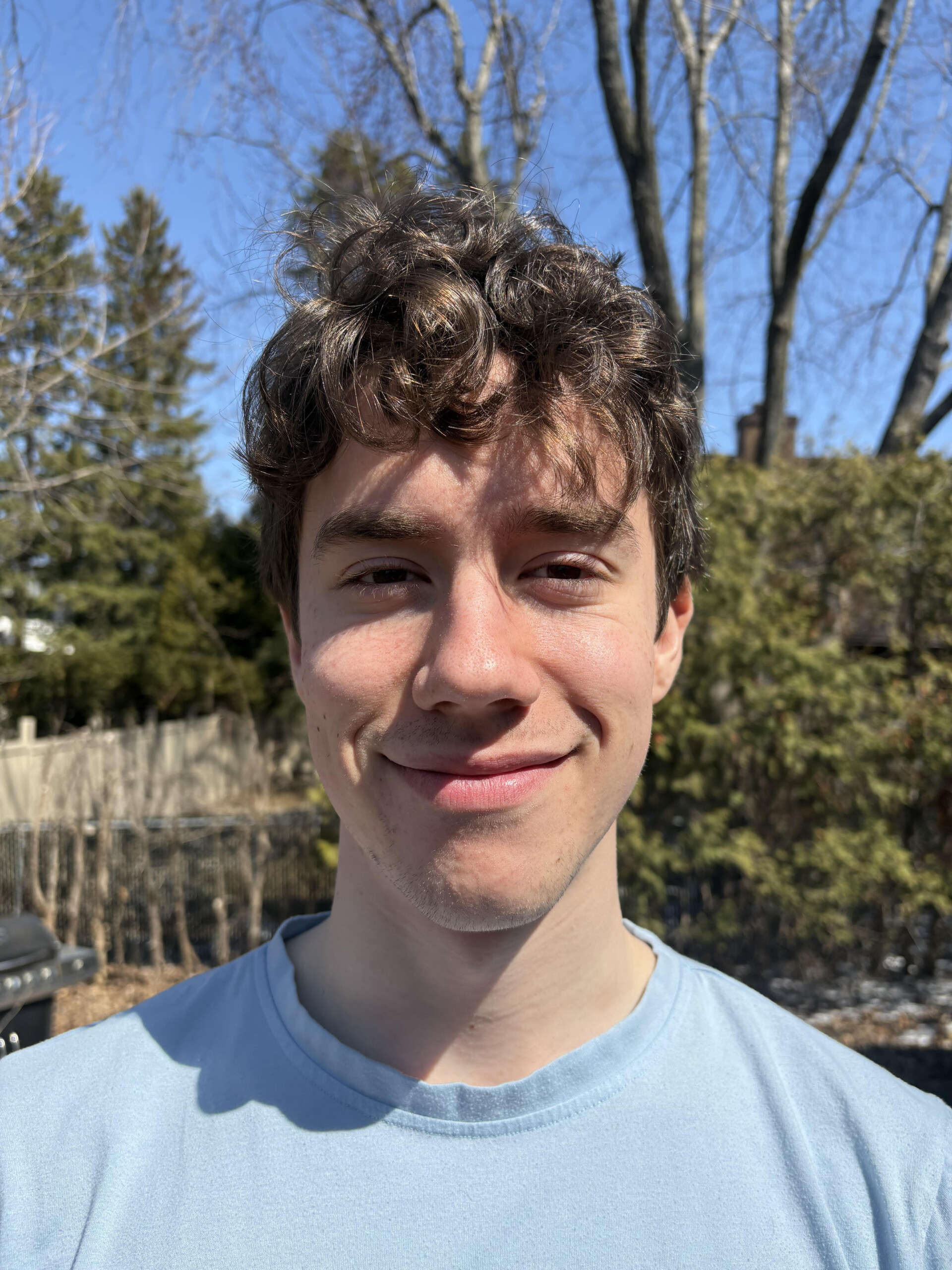 Student with short brown hair posing outside