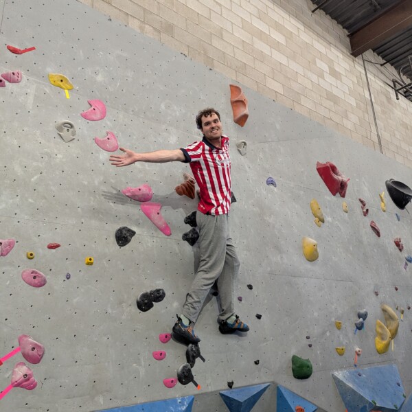 student ambassador on rock climbing wall