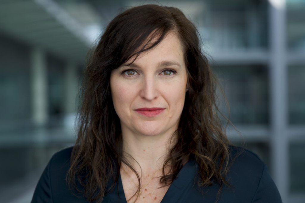 Jen Carswell, who has shoulder-length dark hair and is wearing a dark blazer, photographed inside a modern building.