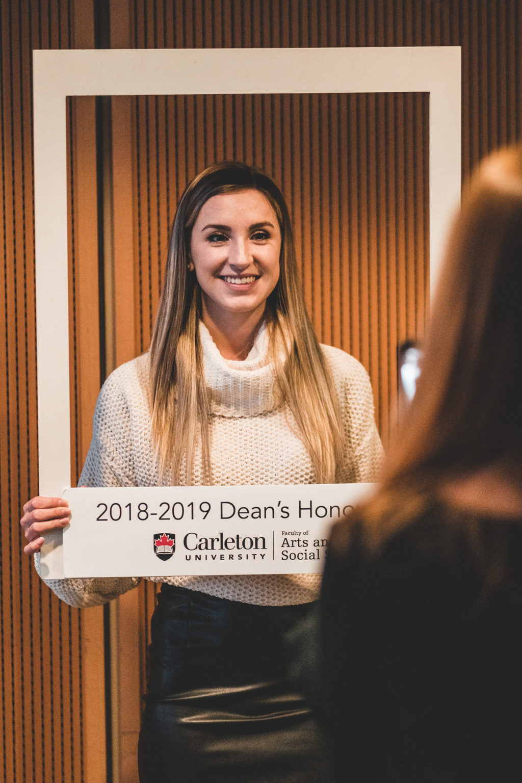 a student poses with 2018-2019 Dean's Honour List sign