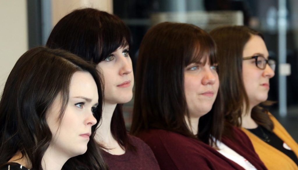 Audience members watching their fellow graduate students present their research.