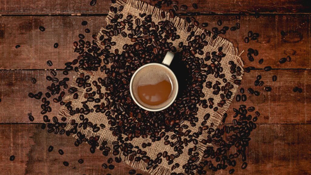 Mug of coffee surrounded by coffee beans