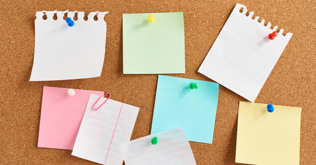 Cork board with a pinned colored blank notes