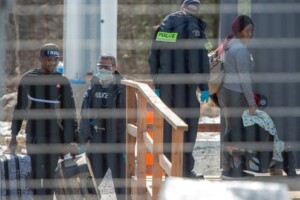 police officers escorting refugees at the Canadian border