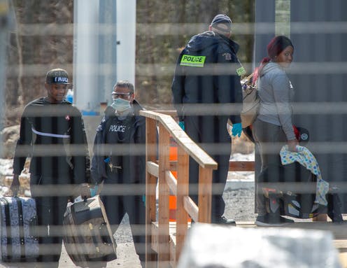 police officers escorting refugees at the Canadian border