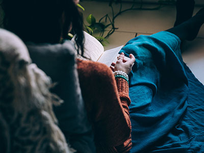 Woman reading a book on the couch