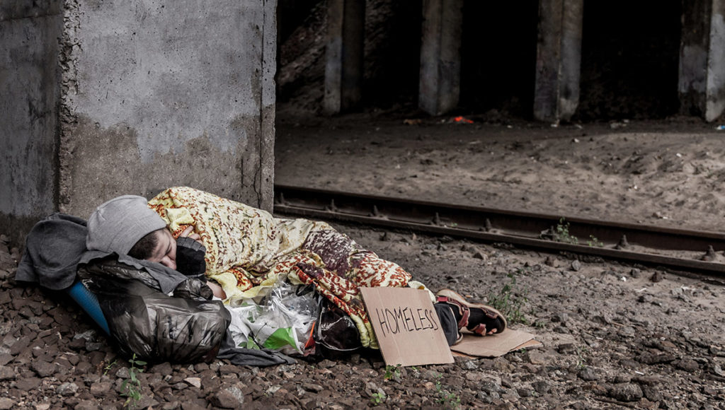 a homeless youth sleeping under a bridge