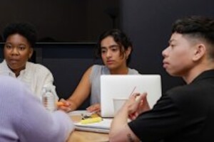 a diverse group of individuals sitting around a table in a meeting