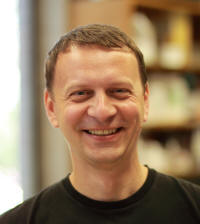 Anatoli is a young faculty member. He is white with short dark hair and is wearing a black sweater.