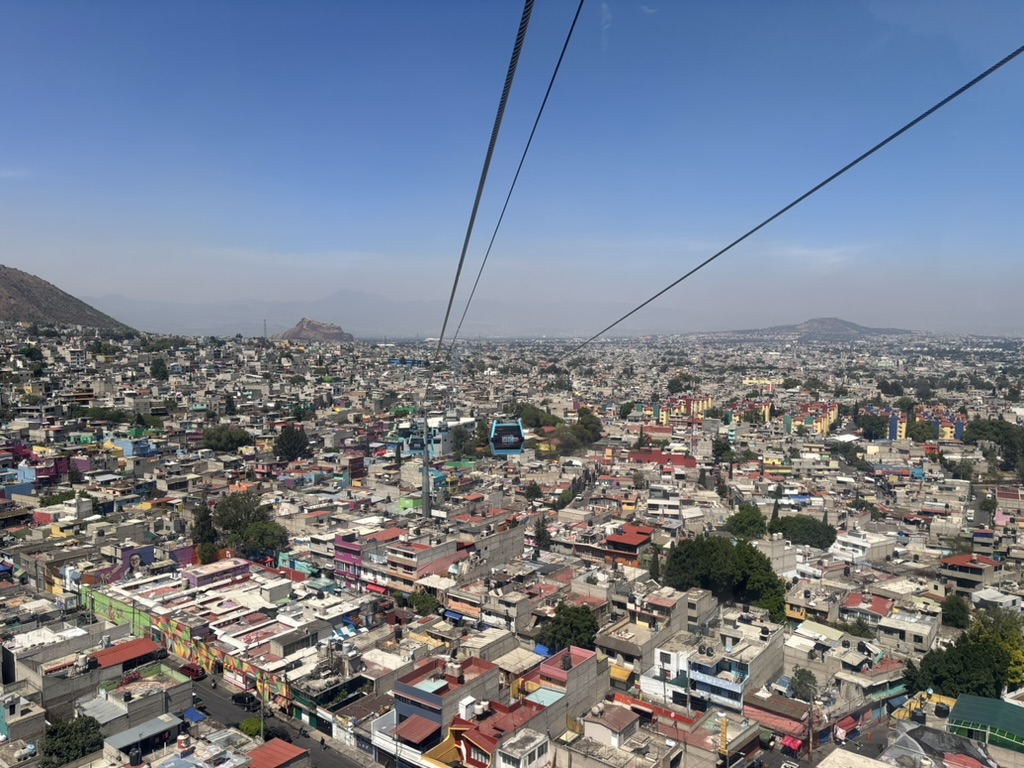 Picture in a cable car looking down at one of the neighbourhoods in Mexico City