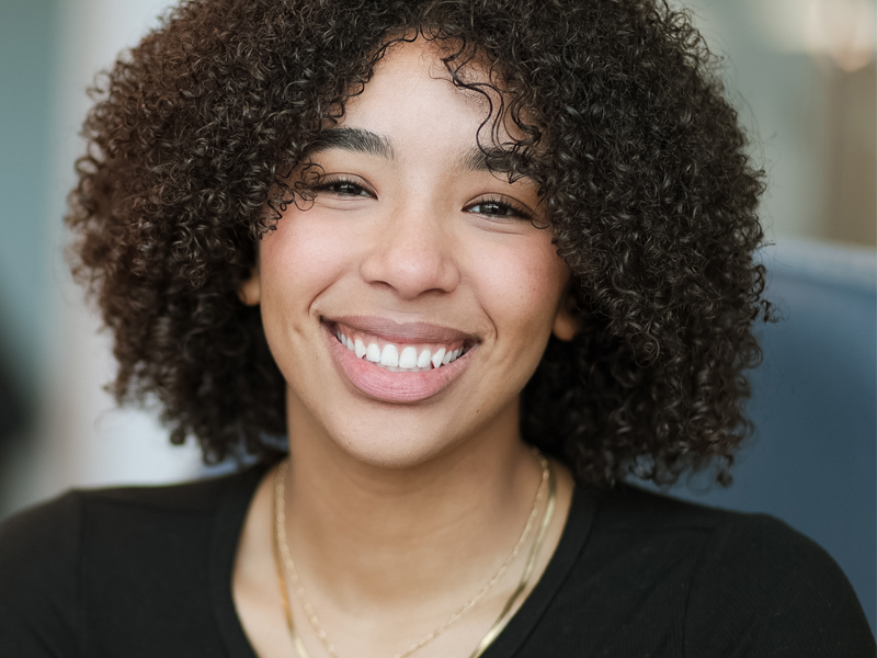 Image of a female student smiling against a blurry background