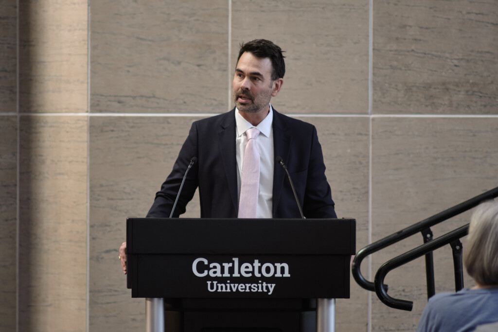 Josh Greenberg at the podium opens the 2026 Bell Lecture