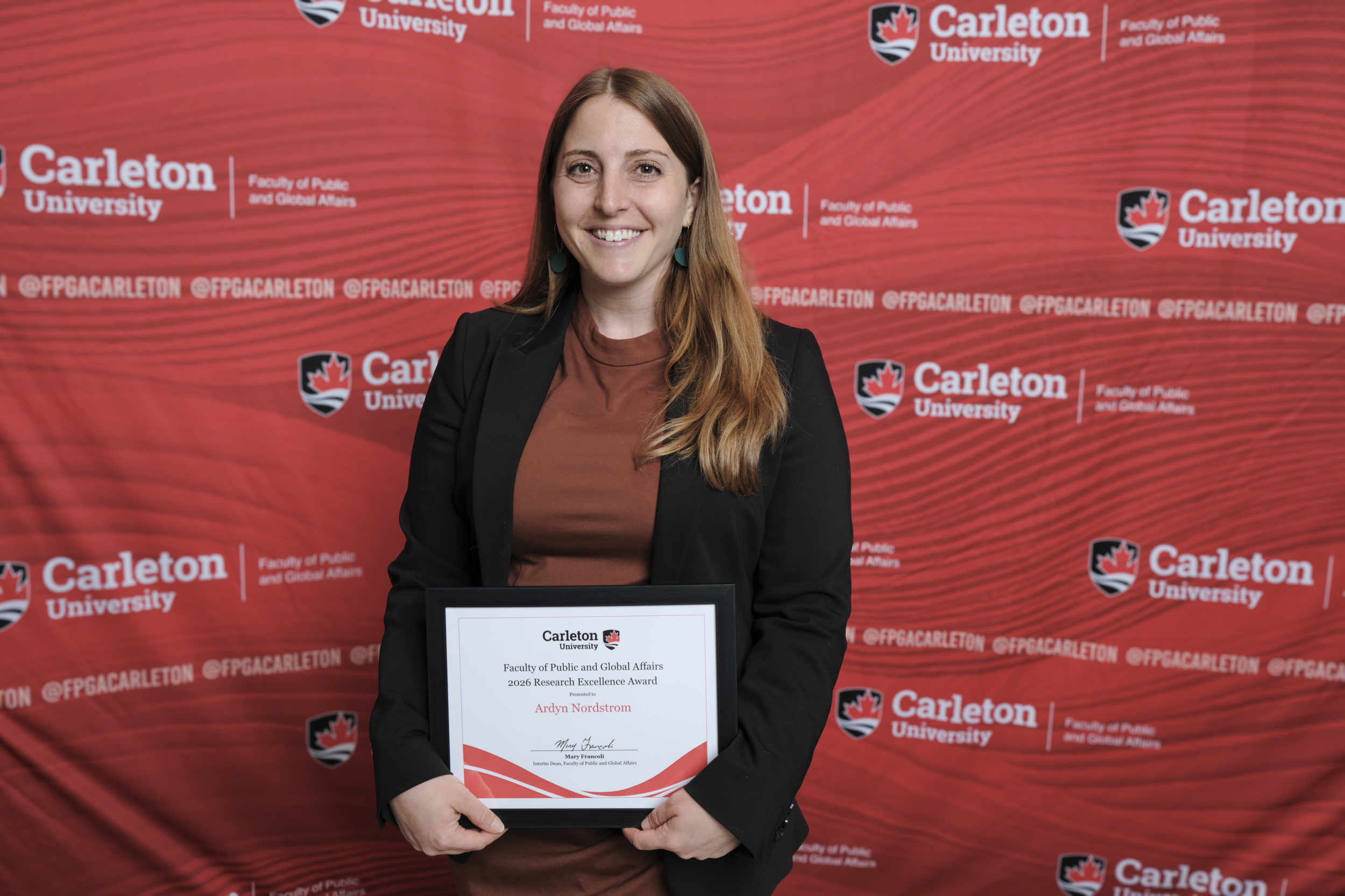 Ardyn Nordstrom poses with the 2026 Research Excellence Award