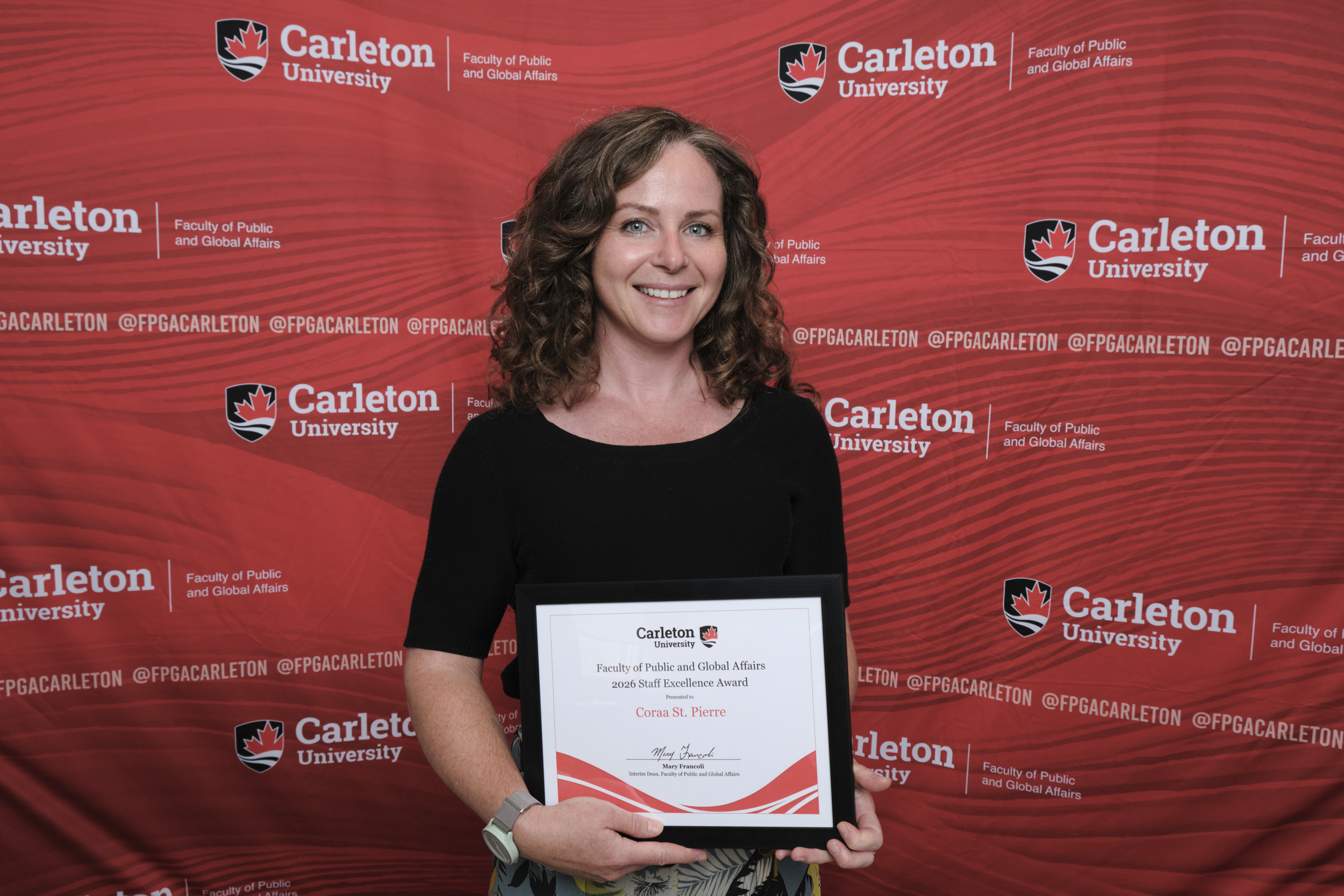Coraa St. Pierre poses with the 2026 Staff Excellence Award
