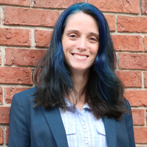 Photo of Tara Connolly posed against a brick wall. 