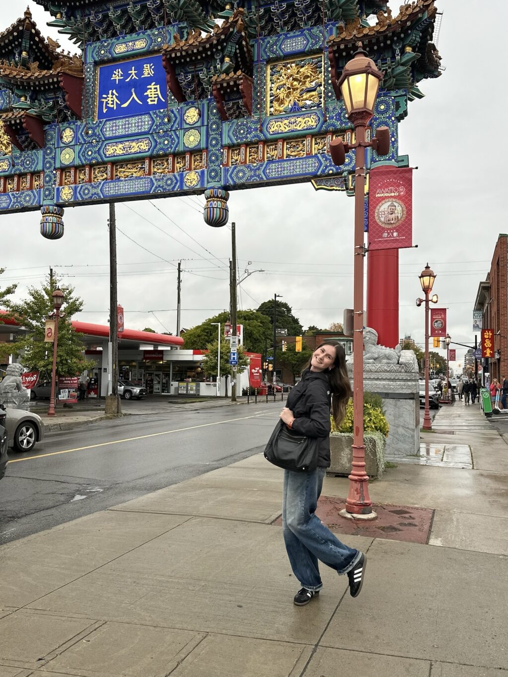 Student posing for photo while outside underneath an overhang street fixture in Chinatown.