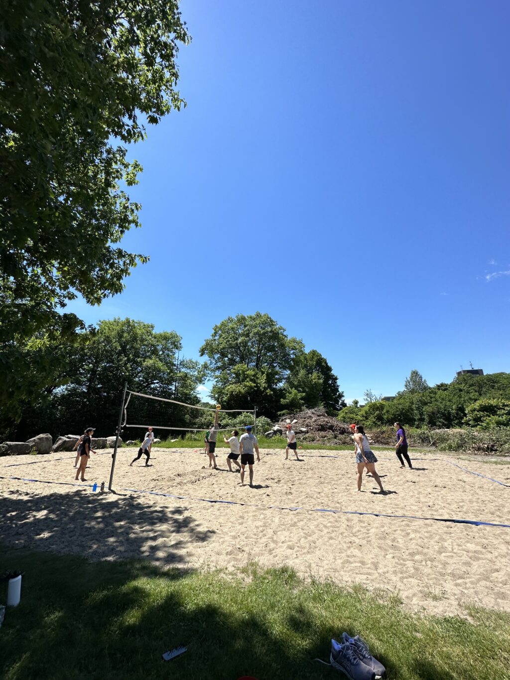 photo of people playing volleyball at sand court on campus