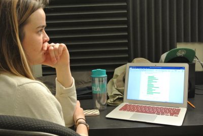 female student sitting at desk in front of laptop screen