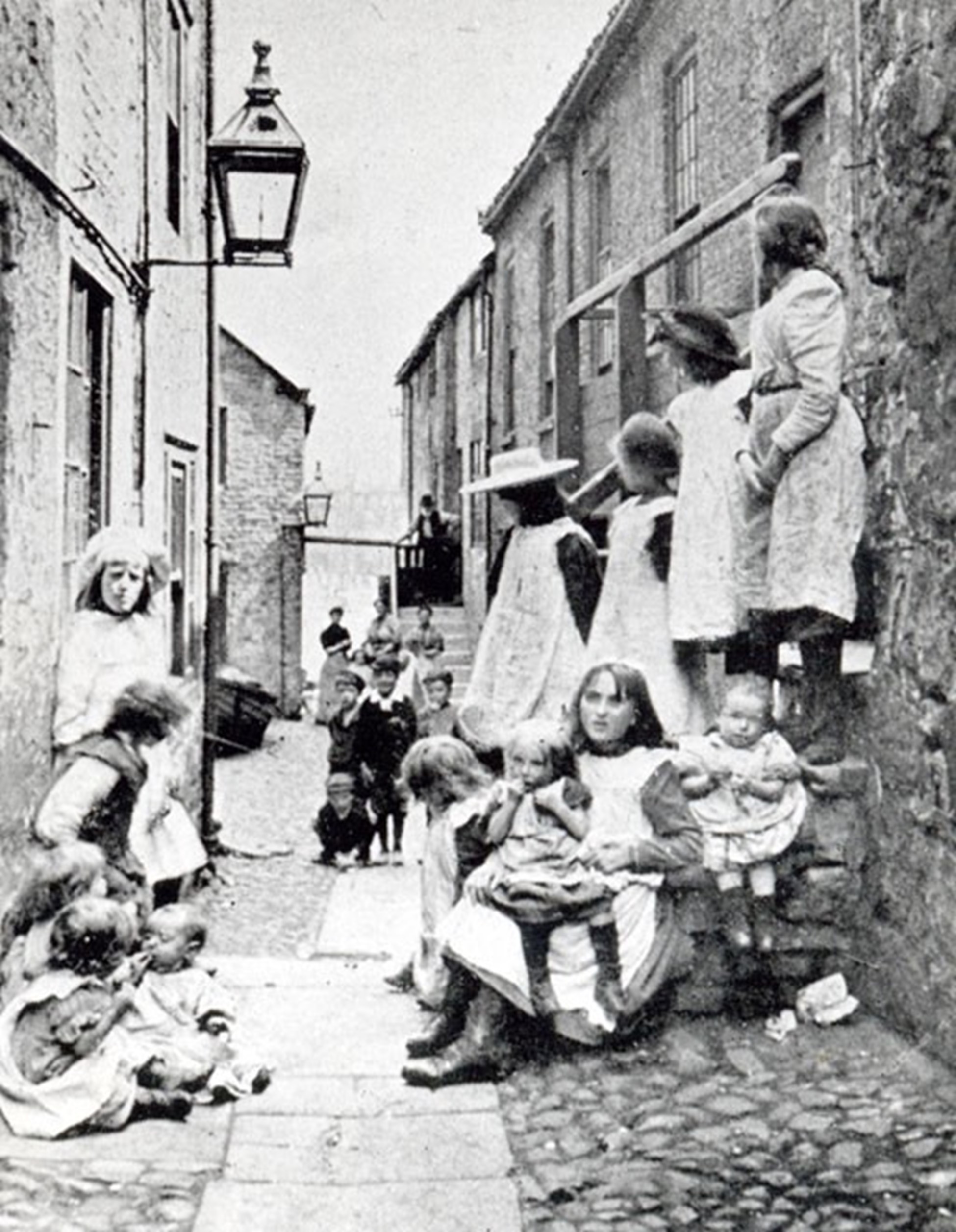 blank and white photo of girls and women in an alley