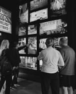 black and white photo of people standing in front of pictures