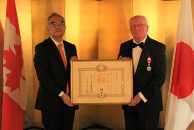 two men standing and holding a framed certificate