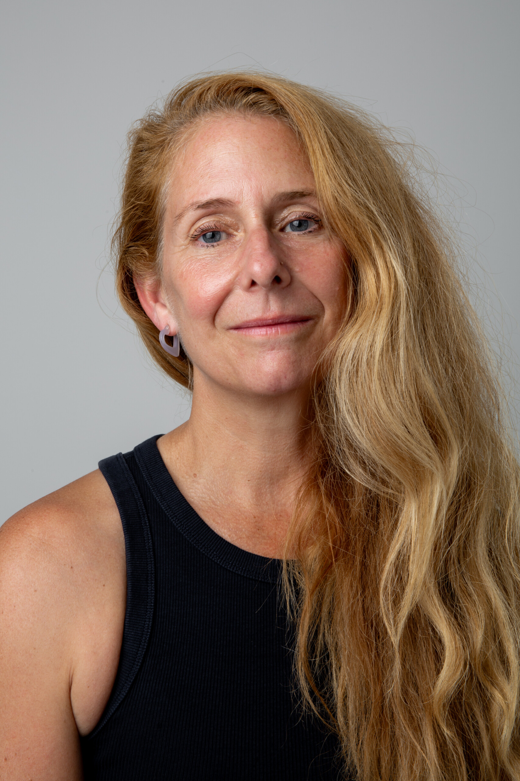 Jen Evans standing in front of a grey wall