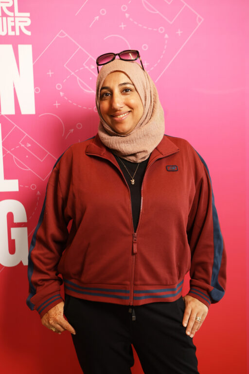 Shireen Ahmed standing in front of a pink backdrop