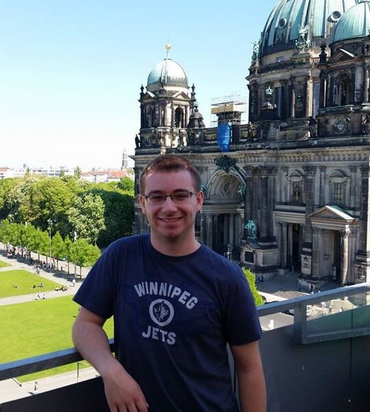 Alan Jones standing outdoors in front of a stone building