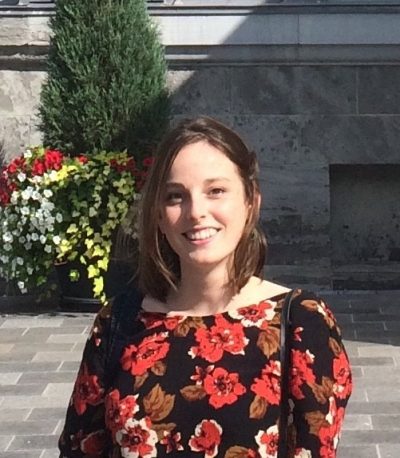 Cristina Wood standing in front of a planter of flowers