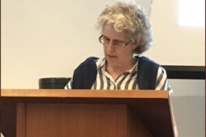 Dominique Marshall standing at a podium speaking