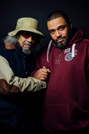 Jalal Nuriddin and Malik Al Nasir clasping hands while facing the camera