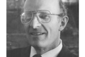 black and white photo of John Taylor wearing glasses