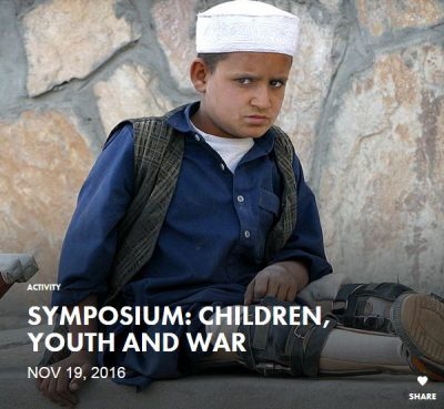 youth with leg braces in a seated position in front of a stone wall