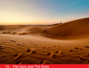 A photo of sand dunes with footprints and a person in the far distance.