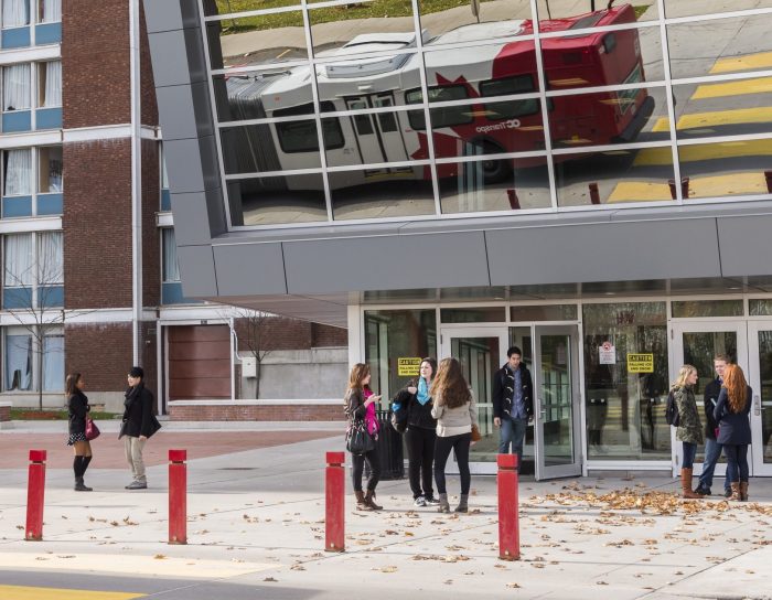 Students talk in front of the Residence Commons building.