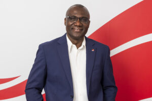 President Wisdom Tettey standing in front of Carleton wave imagery