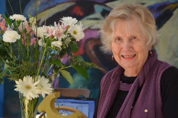 Landon Pearson stands near flowers