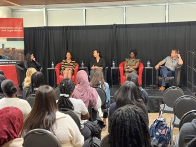Four Carleton alumni and the department chair on stage
