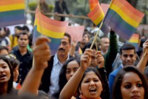 Crowd of people in India waving LGBT flags