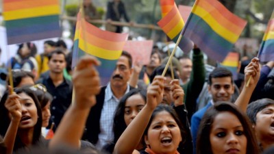 Crowd of people in India waving LGBT flags