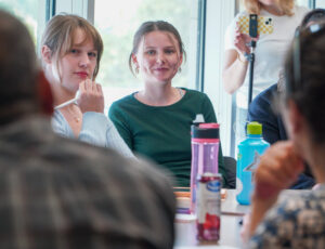 Two students listen attentively during a discussion led by Dr. Ritesh Shah.