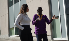 Description: Georgiana Ghitau and Deo Mwapinga discussing his research outside the Canal Building at Carleton University. 