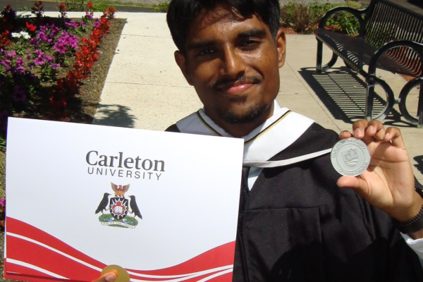 Jarukson holding his degree and medal