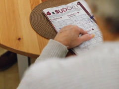 An elderly person filling in a sudoku table
