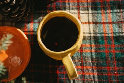 Coffee mug on table with plaid